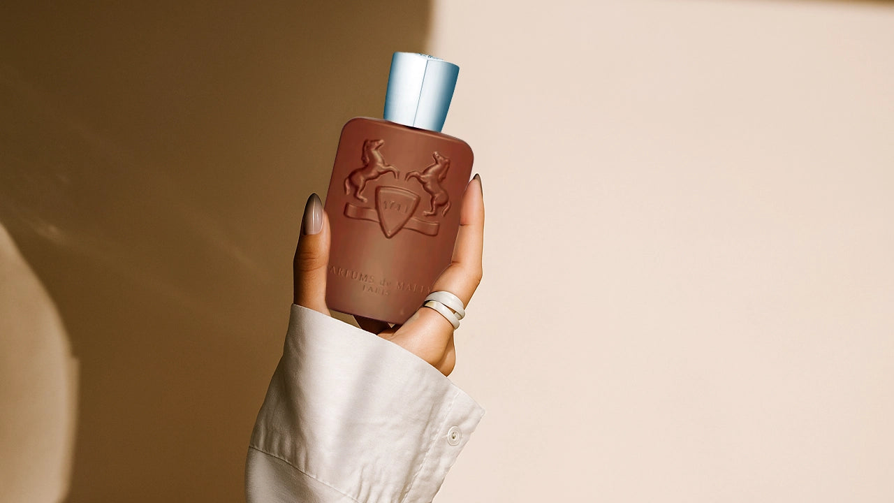 Brown bottle with a blue cap held by a hand against a beige background